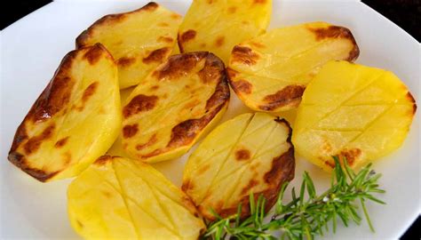 Patatas laminadas al horno, dispuestas verticalmente, con puntas doradas.