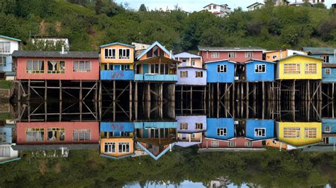 Vista panorámica de los palafitos de Castro reflejándose en el agua.