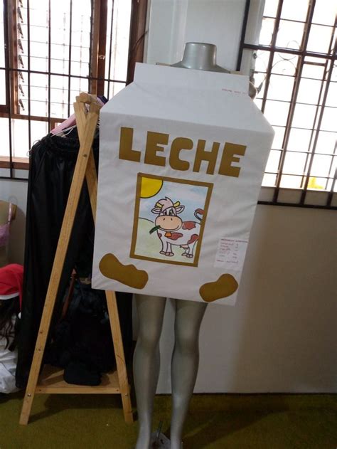 Niño sonriente vestido con un disfraz de cartón de leche.