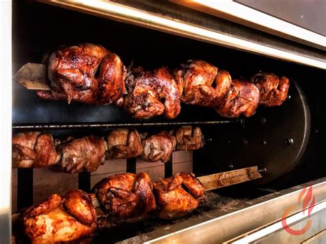 Asador de pollo a las brasas en funcionamiento en un establecimiento