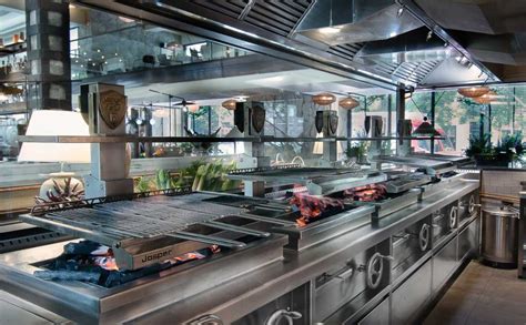 Interior elegante y acogedor de un restaurante Santa Brasa con vista a la parrilla abierta.