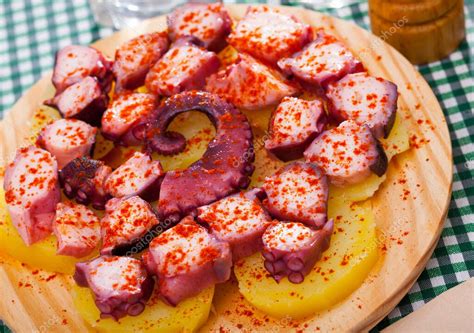 Plato de pulpo a la plancha servido con vinagreta y acompañamiento de patatas