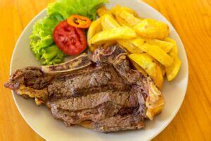 Churrasco con papas fritas, guacamole y pico de gallo en un plato grande