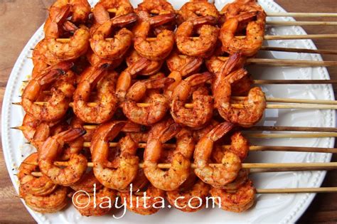 Brochetas de camarón asándose en la parrilla