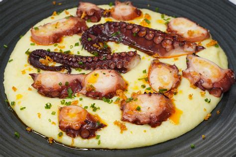 Plato de Pulpo a la parrilla con papas confitadas, presentado elegantemente.