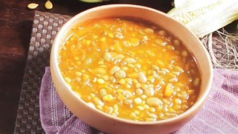 Fotografía de un plato humeante de porotos con mote y trozos de zapallo