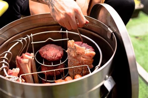 Esquema de un ahumador tradicional mostrando la circulación del humo y la colocación de la carne sobre fuego indirecto