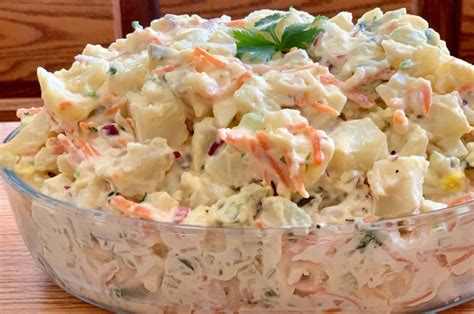 Ingredientes frescos para ensalada de papas: papas cocidas, zanahoria, cebollín, huevo duro y mayonesa