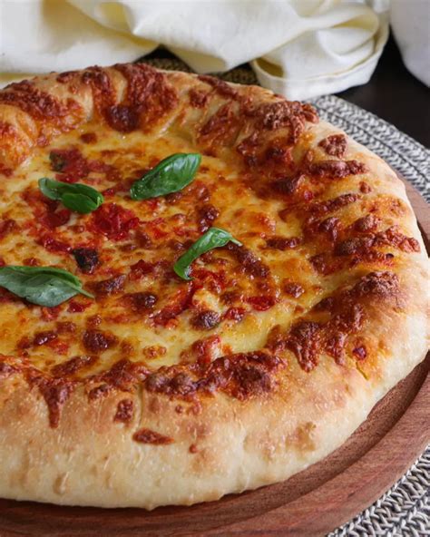 Imagen de una pizza de Pizza Hut con borde relleno de chorizo y una bebida al lado