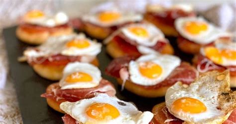 Fotografía profesional de canapés de huevo de codorniz con rodajas de chorizo sobre pan tostado