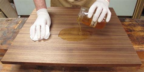 Detalle de una tabla de madera siendo tratada con aceite alimentario