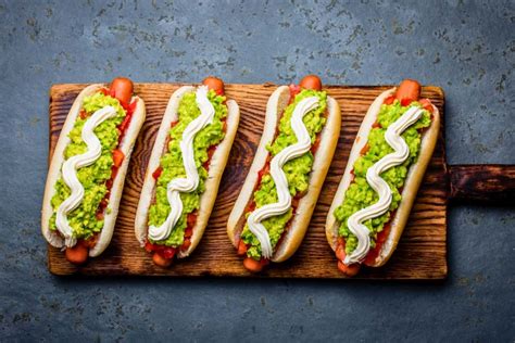 Plato de completos variados con diferentes ingredientes y salsas.