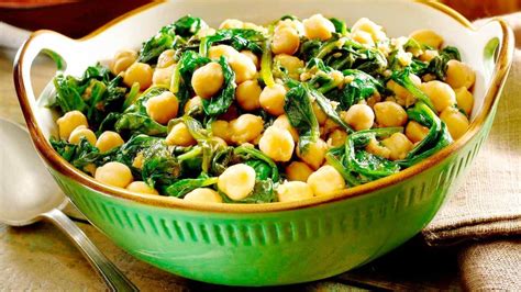 Espinacas frescas añadiéndose a la olla con garbanzos