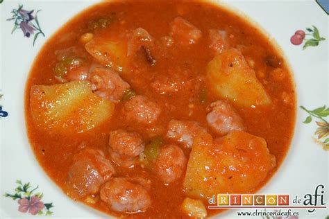 fotografía de un guiso de longanizas a la cerveza en cazuela de barro con cebolla pochada y salsa reducida