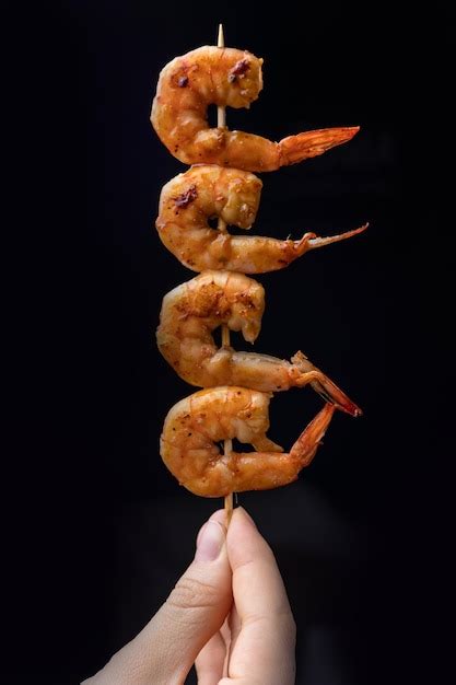 Primer plano de camarones salteándose en una sartén caliente hasta obtener un tono rosado perfecto.