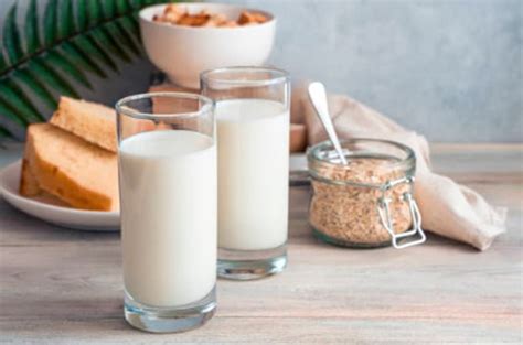 Descripción de imagen: Avena cubana cremosa servida en un vaso alto con hielo, decorada con una rama de canela.