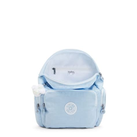 Ilustración de la mochila Seoul de Kipling en color celeste pastel con detalles característicos de la marca.