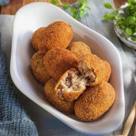 Plato de croquetas de carne molida doradas en un sartén