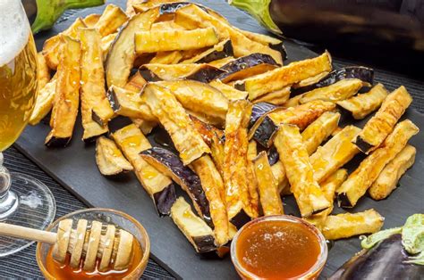 Plato de berenjenas fritas doradas y crujientes regadas con miel de caña