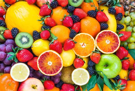Bodegón de frutas frescas de temporada sobre una mesa de madera rústica