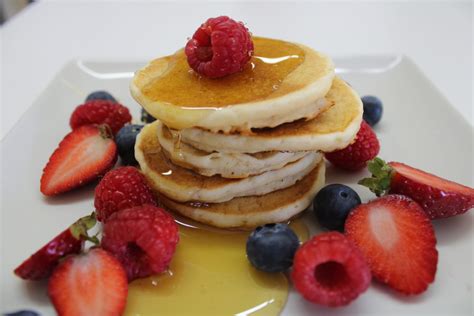 Foto de pancakes esponjosos apilados con frutas y sirope