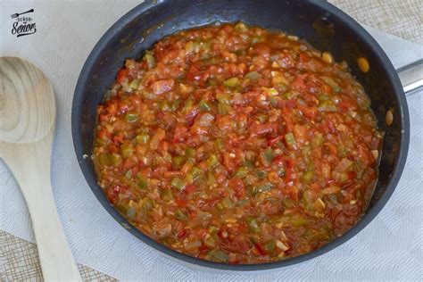 Imagen de un sofrito de verduras y cabezas de gambas en una cazuela