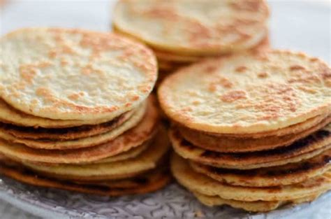 Fotografía de primer plano de tortillas dulces crujientes espolvoreadas con azúcar y canela junto a un cuenco de chocolate fundido