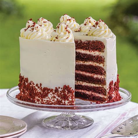 Photo of a vibrant red velvet cake with dripping white chocolate ganache