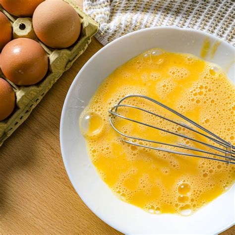 Proceso de batido de huevos con azúcar y aceite para la masa del budín.