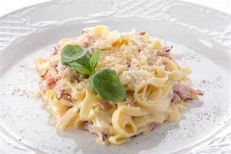 Plato servido de coditos con queso y tocino, decorado con perejil fresco picado.