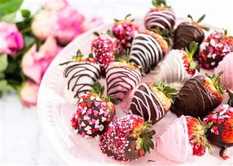 Plato con variedad de postres pequeños para San Valentín: fresas con chocolate, mini-tartaletas, bombones