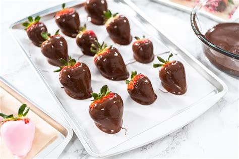 Fresas frescas con forma de corazón bañadas en chocolate sobre una bandeja, con un toque romántico