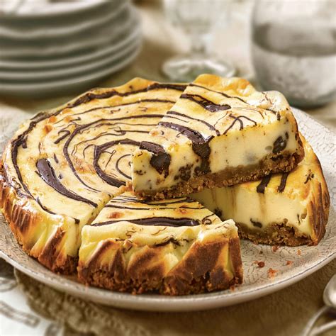 Tarta de queso y chocolate con forma de corazón decorada con frutos rojos y un ligero glaseado de cacao