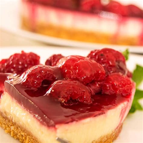 Vista de una tarta de mascarpone y frambuesas con una base crujiente, decorada con frambuesas frescas