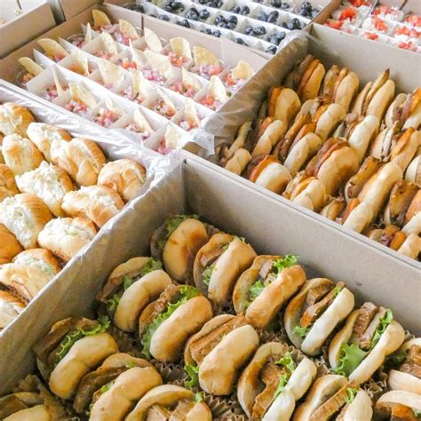 Variedad de mini sandwiches y bocadillos salados presentados en bandejas para catering