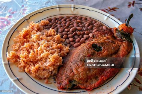 chicharrón en salsa de chipotle servido con arroz, frijoles y tortillas de maíz