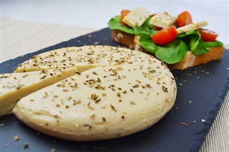 Composición de ingredientes para queso vegano: tahini, levadura nutricional, hierbas y especias.