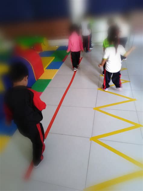 Niño caminando sobre una línea recta en el suelo como ejercicio de equilibrio