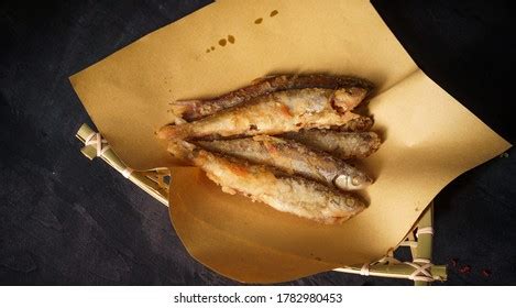 Pescado frito escurriéndose sobre papel absorbente