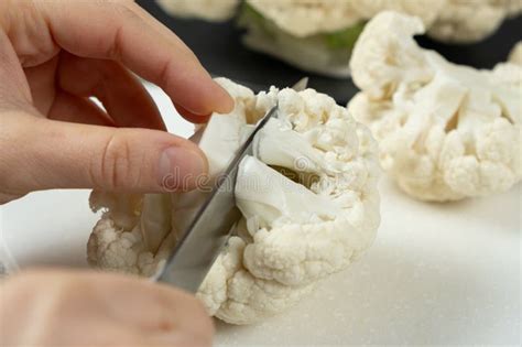 Una mujer cortando una coliflor fresca