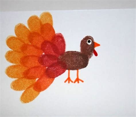 Pavo hecho con pasta pegada en una cartulina, con ojos móviles