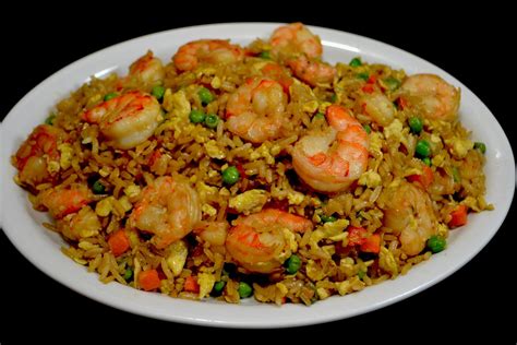 Imagen de un plato de arroz frito con camarones, huevos revueltos, carne y trozos de palta