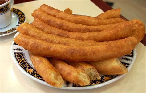 Primer plano de la masa de churros siendo formada con una churrera.