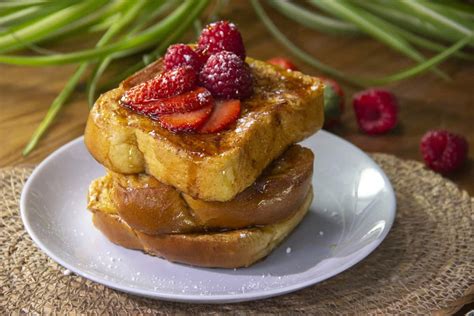 tostadas francesas decoradas con frutos rojos y corazones hechos con leche condensada