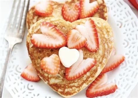 pancakes en forma de corazón decorados con frutos rojos y una flecha