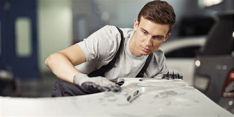 Un pintor automotriz trabajando en la preparación de un vehículo