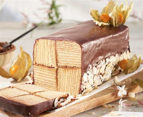Fotografía de un Baumkuchen finalizado con su cobertura de chocolate brillante y almendras.