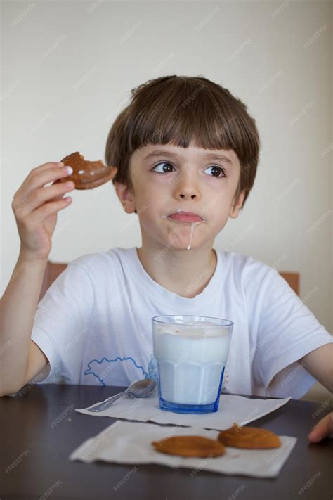 Niño desayunando galletas María mojadas en leche en un tazón