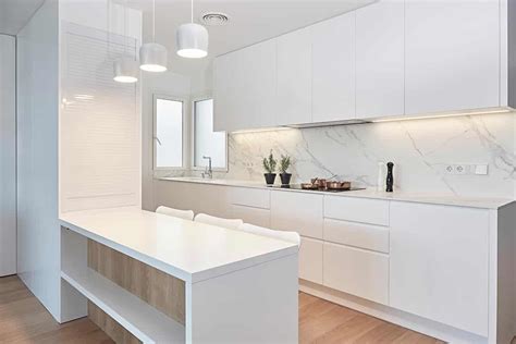 Cocina moderna y luminosa con electrodomésticos blancos y muebles de líneas puras