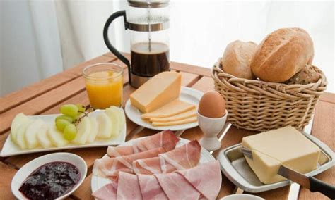 Foto temática que muestra un desayuno tradicional alemán con diversos tipos de mermelada y bollería.